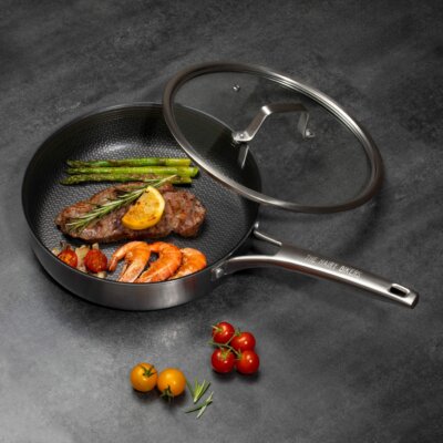 A HexGuard™ sauté  pan with a steak and prawns in it.